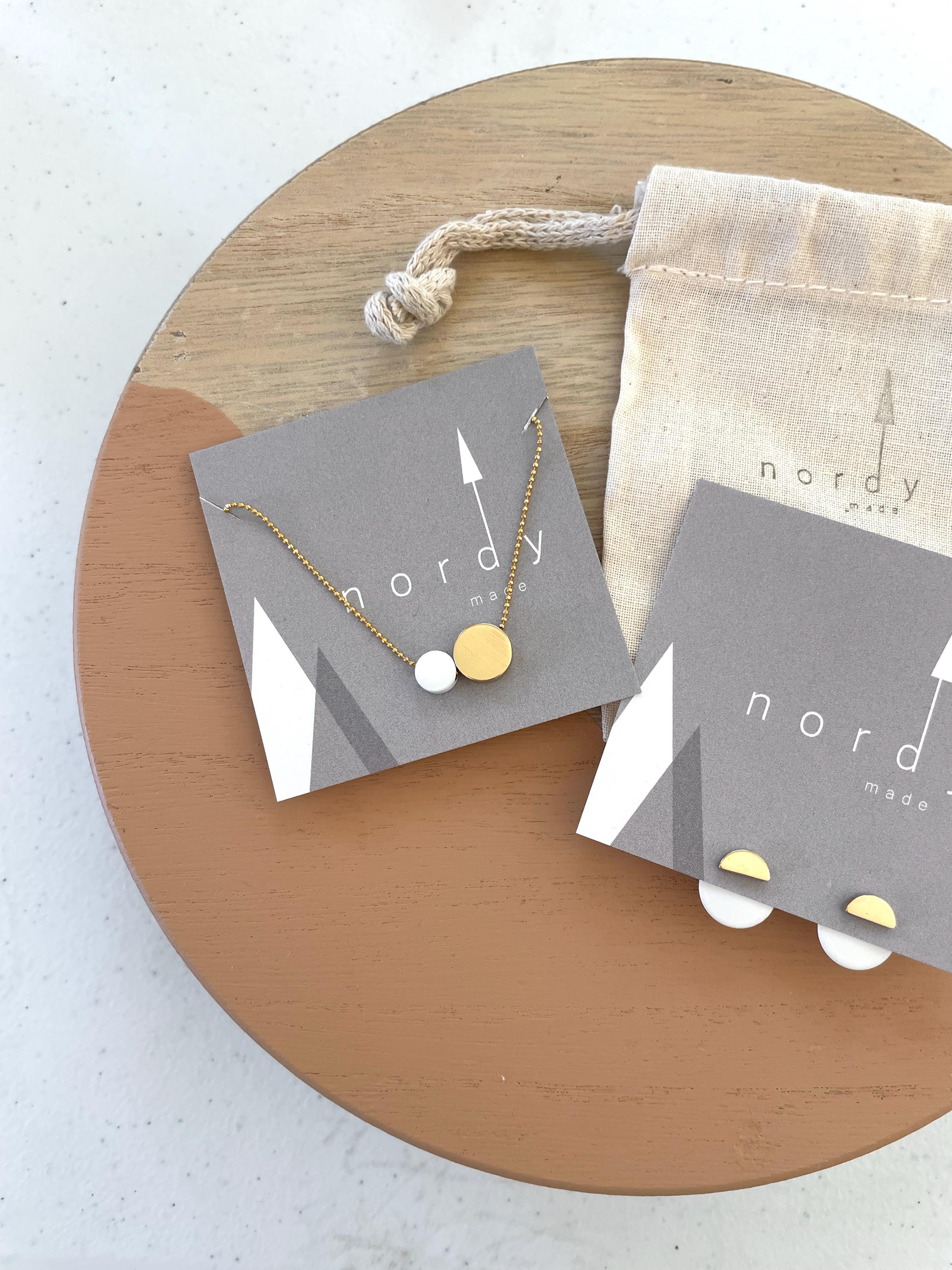 MILA ear jackets shown in BRASS (studs) with contrasting WHITE ear jackets. Also pictured is the complimentary NOME 2 dots &quot;together&quot; necklace in brass and white.